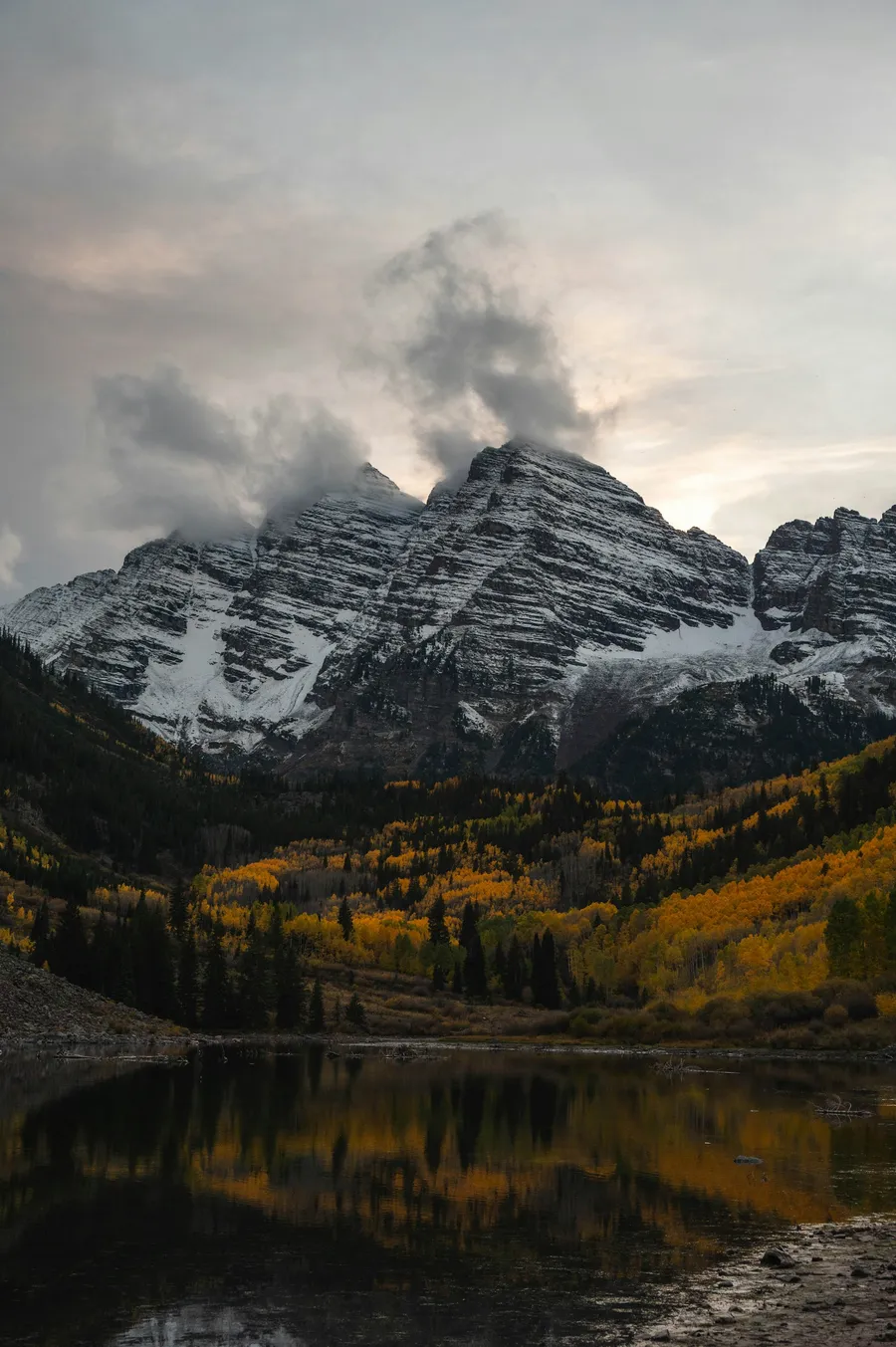 An alpine lake surrounded by aspen trees and mountains in Colorado